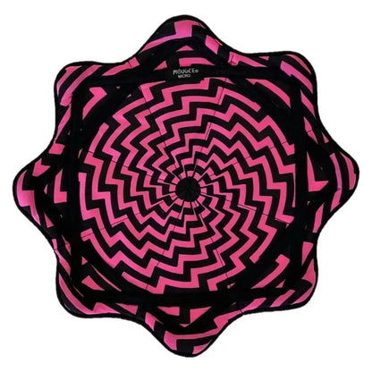 Black and pink spiral patterned fabric cushion with a starburst design.